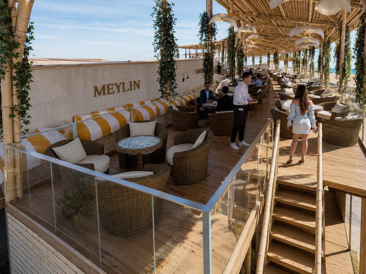 Terraza Meylin de AQUALODGE con sofás y sombrillas frente a la playa