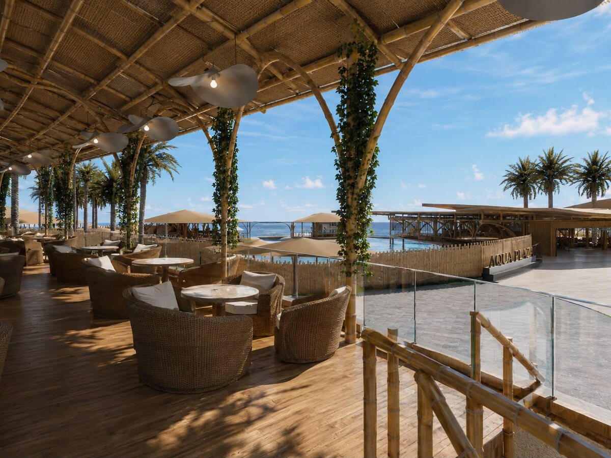 Lounge techado de bambú del beach club de AQUALODGE con butacas de ratán frente al mar