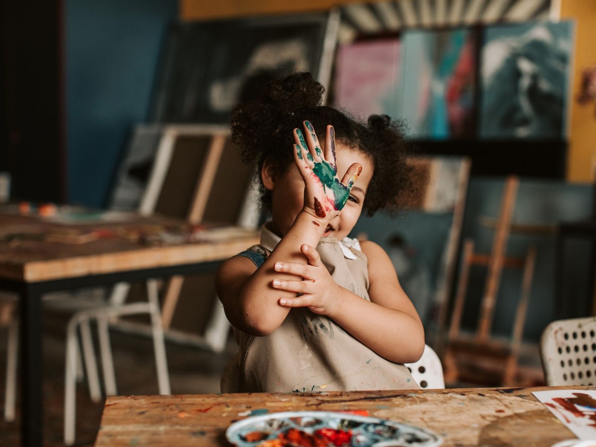 Niña con las manos pintadas en un taller creativo de Aqua Kids