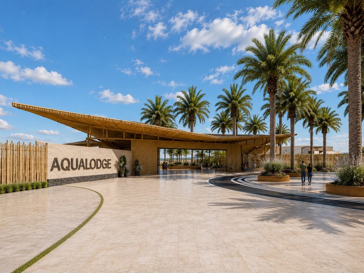 Ingreso principal de AQUALODGE con el techo volado de bambú y el muro con el nombre del resort — Playa Hermosa, Tumbes
